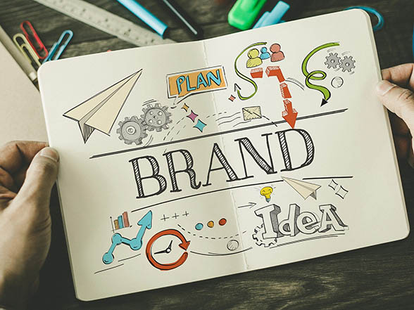 Notebook with colorful brand related sketches indicating how PPC advertising generates brand recognition.