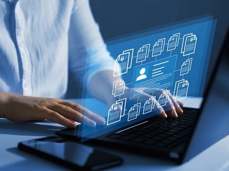 Digital content files displayed above laptop representing online content marketing services.